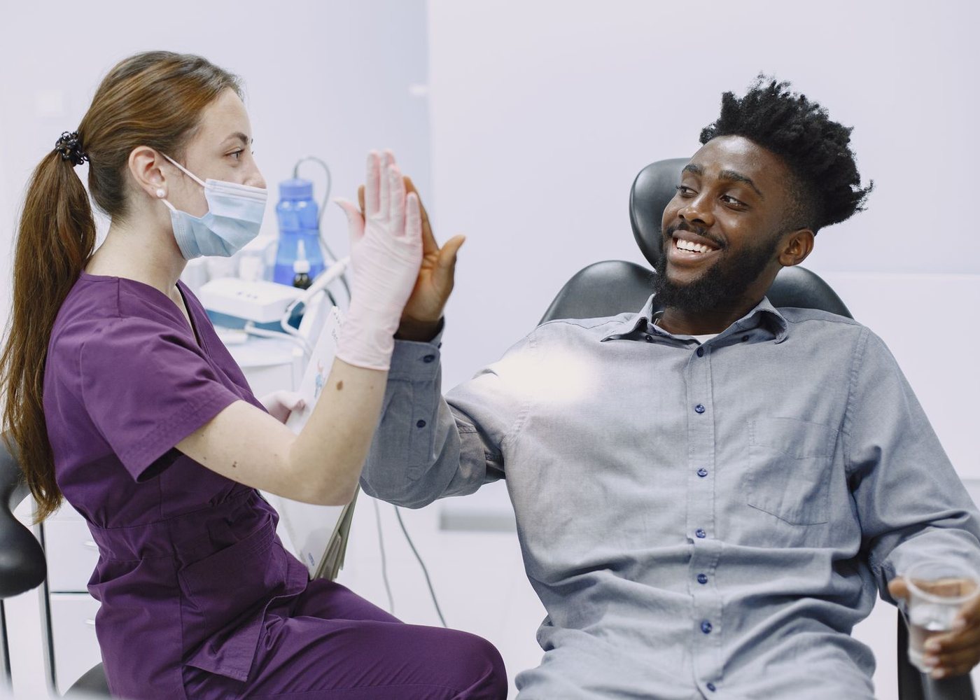 Dentist and smiling patient celebrating after treatment